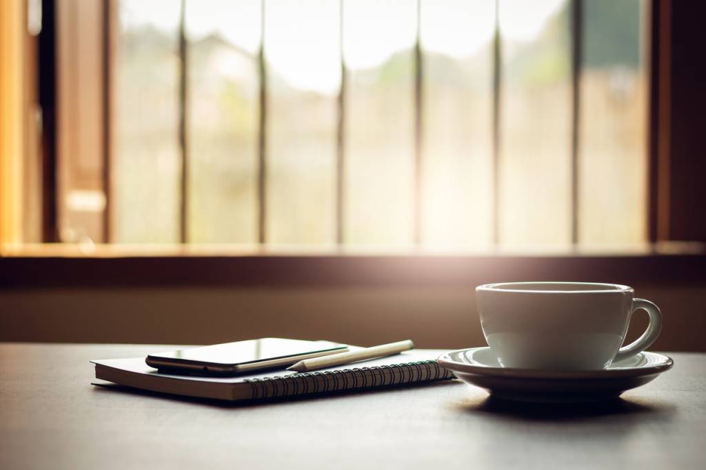 Mindful moment with coffee, notebook, and mobile phone reflecting on life