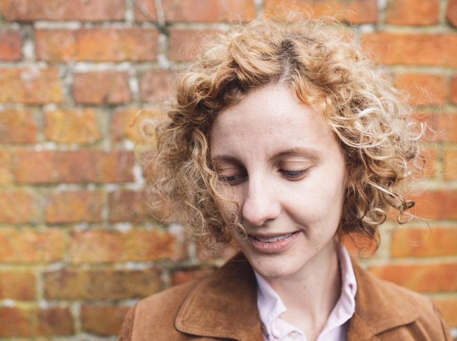 Woman standing outside looking down, representing low self-esteem and lack of confidence