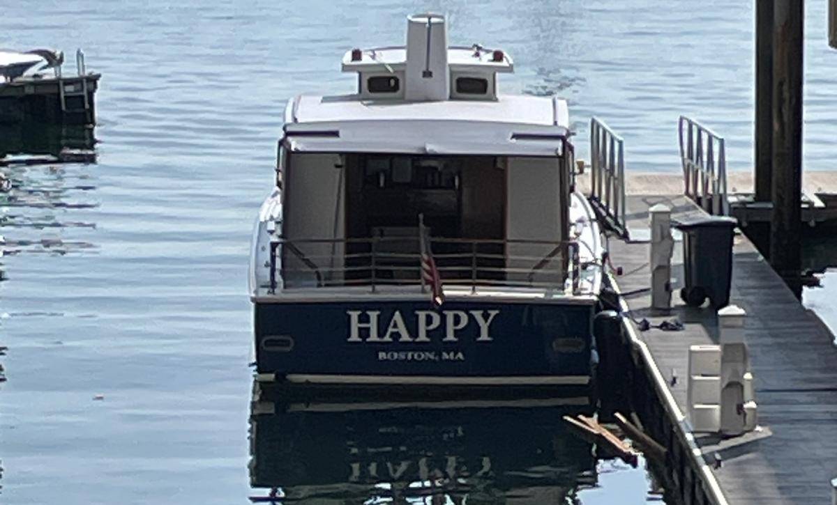 A boat named 'Happy' seen from the rear which represents the pursuit of a happy state.