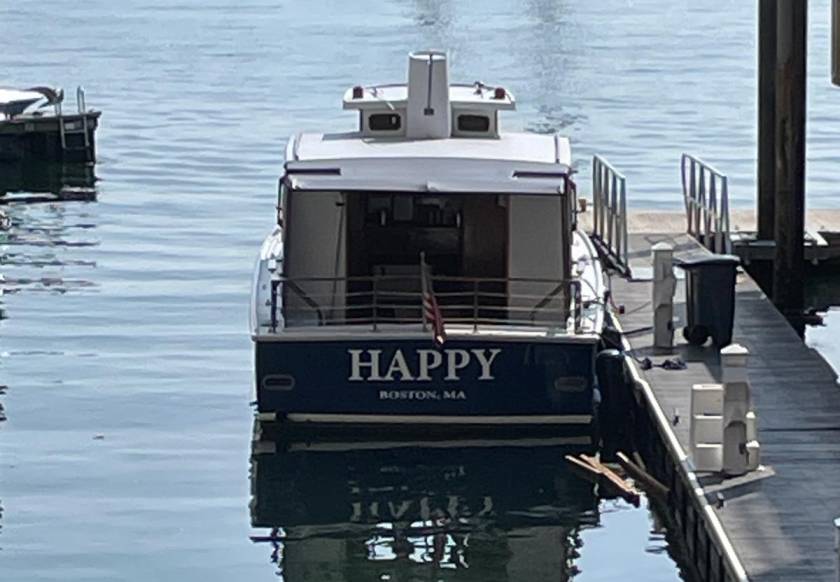 A boat named 'Happy' seen from the rear which represents the pursuit of a happy state.