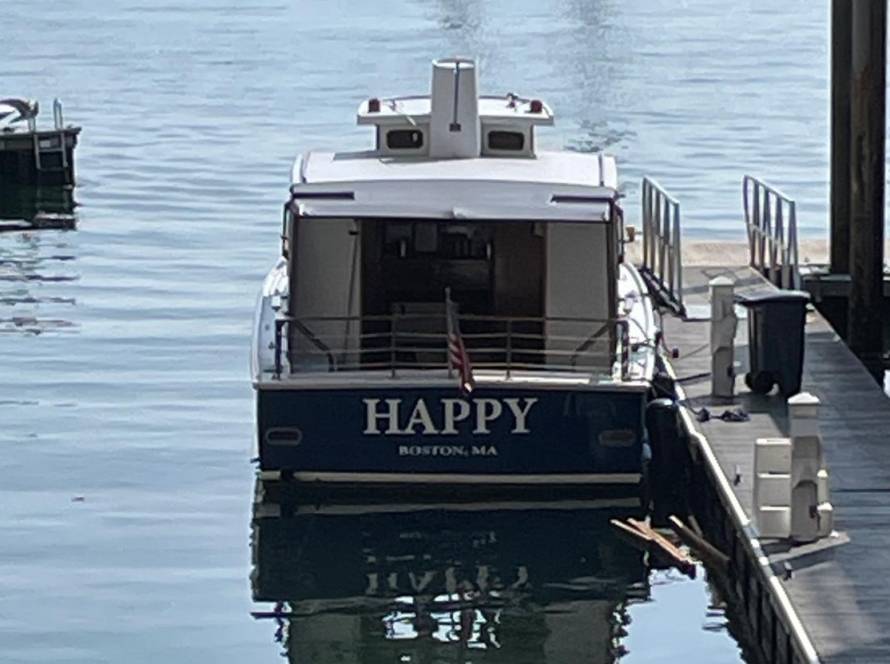 A boat named 'Happy' seen from the rear which represents the pursuit of a happy state.