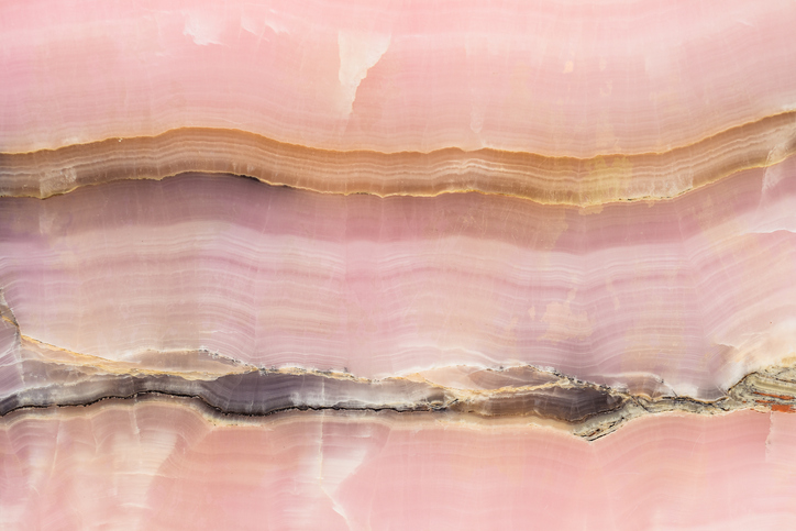 Pink jade stone with two visible fault lines, symbolising the difference between disordered eating and eating disorders.