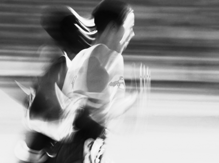A blurred image of a woman running in athletic gear, symbolising the body’s instinct to flee from perceived danger.