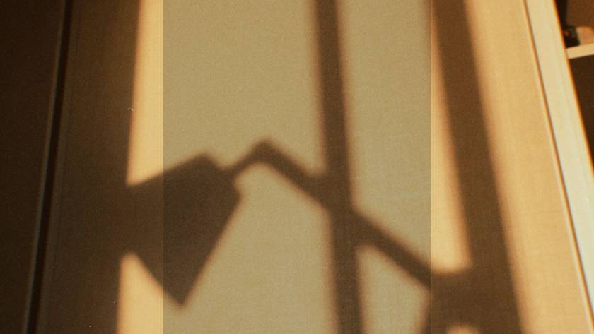 Warm golden shadow cast on a wall, representing the complex relationship between eating disorders and social media