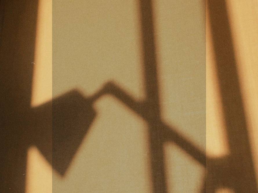 Warm golden shadow cast on a wall, representing the complex relationship between eating disorders and social media