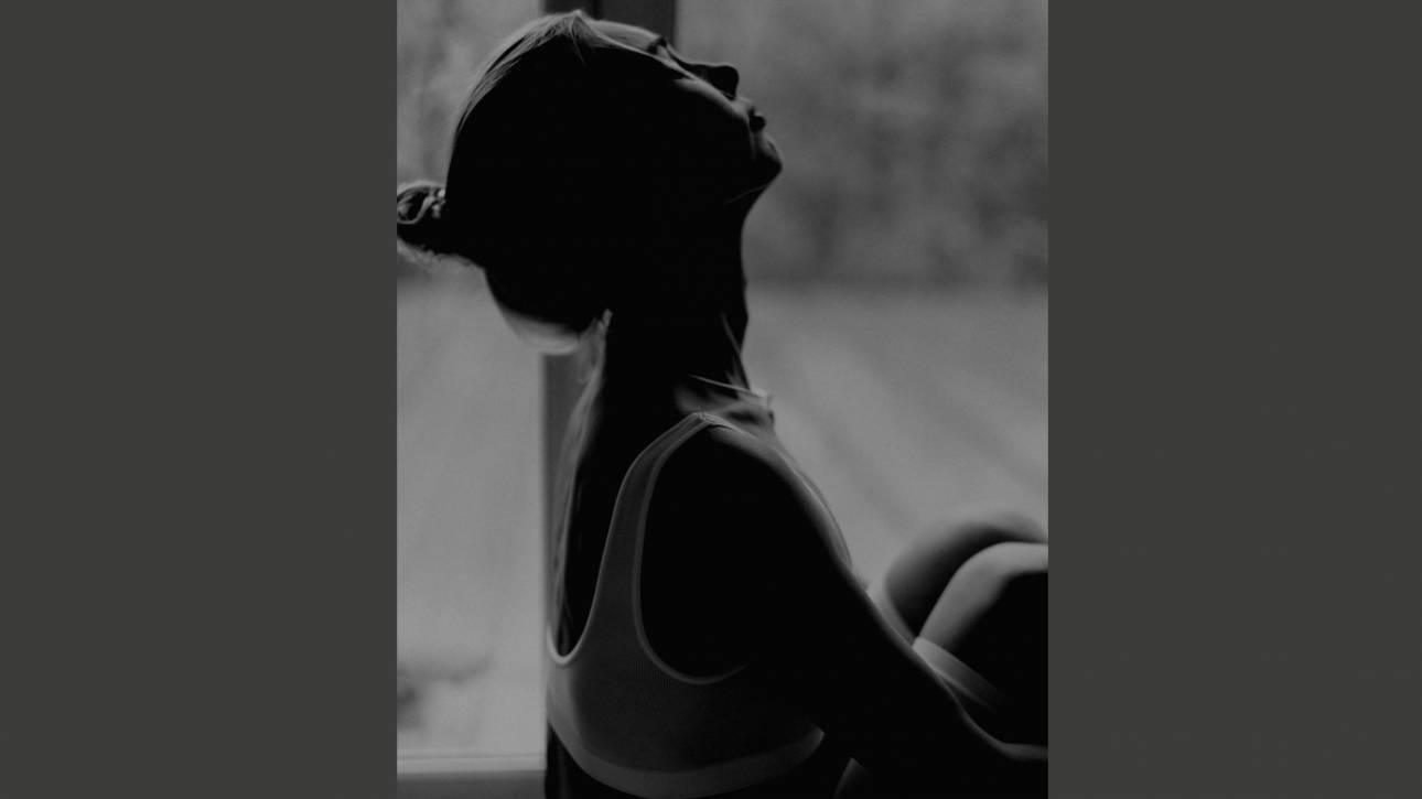 A woman in silhouette with face tilted upward, partially in shadow, representing the feeling of being unseen and invisible despite being present.