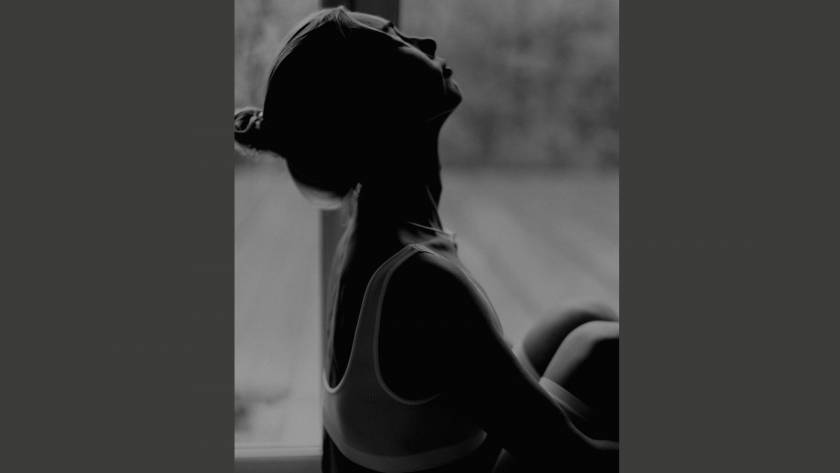 A woman in silhouette with face tilted upward, partially in shadow, representing the feeling of being unseen and invisible despite being present.