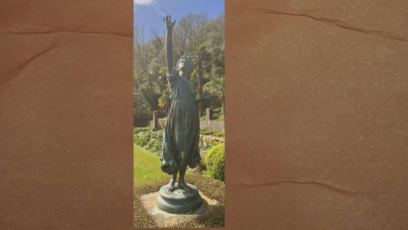 Bronze statue of a figure reaching upward in a sunlit garden, representing the feeling of striving to move forward despite something holding you back