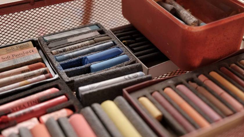 A vintage box of soft pastels in warm earthy tones, representing the rediscovery of creativity and its role in mental wellbeing