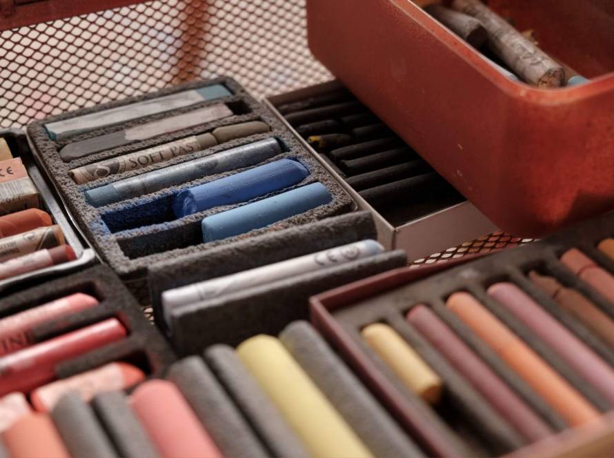 A vintage box of soft pastels in warm earthy tones, representing the rediscovery of creativity and its role in mental wellbeing