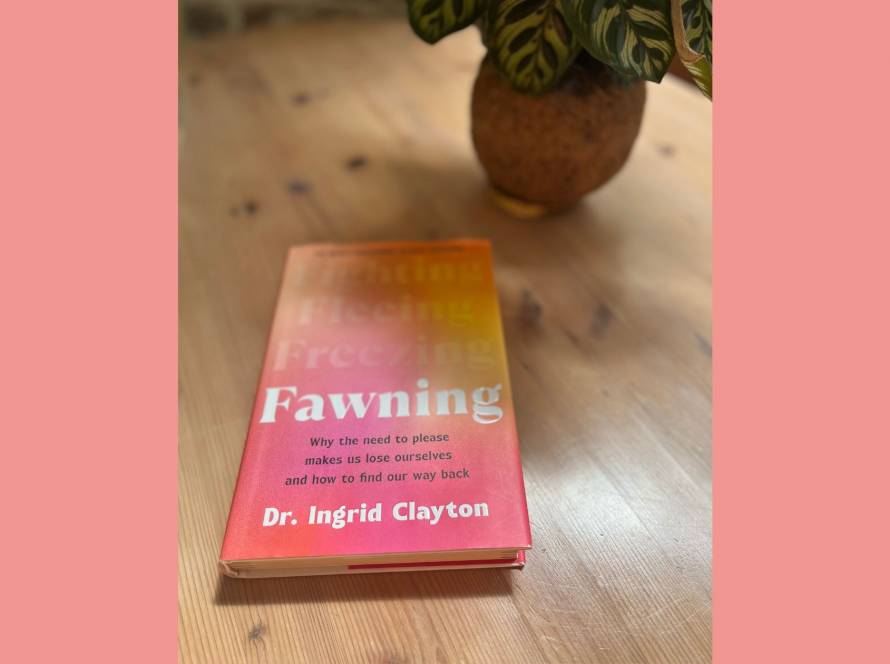 Personal photograph of Fawning by Dr Ingrid Clayton on a wooden desk beside a plant in warm spring light.
