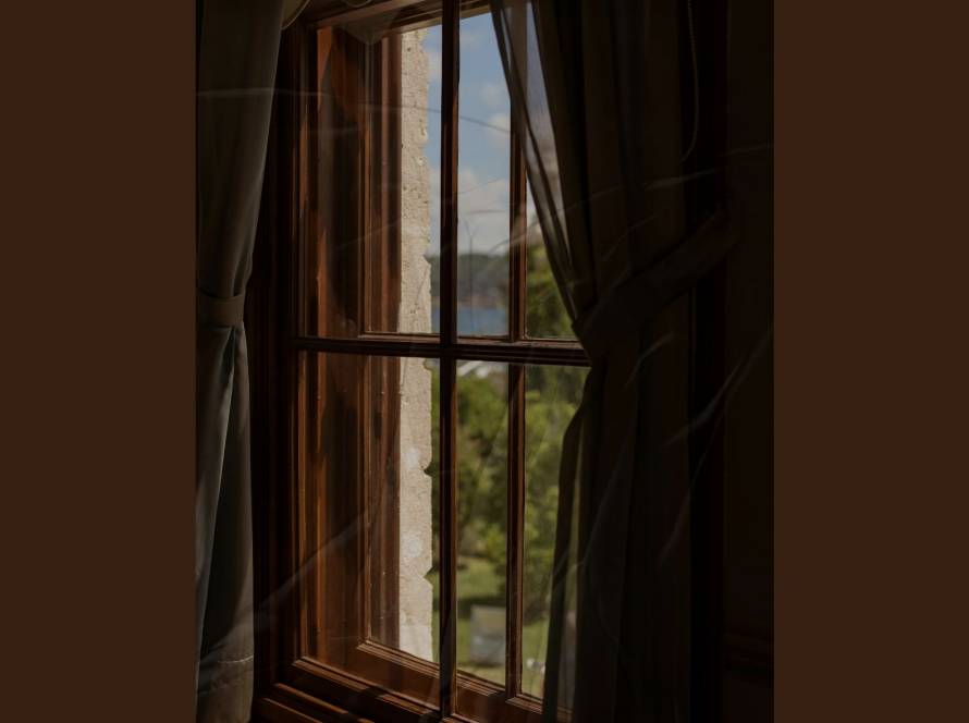 A view through a window with soft curtain detail, illustrating the suspended state of burnout recovery