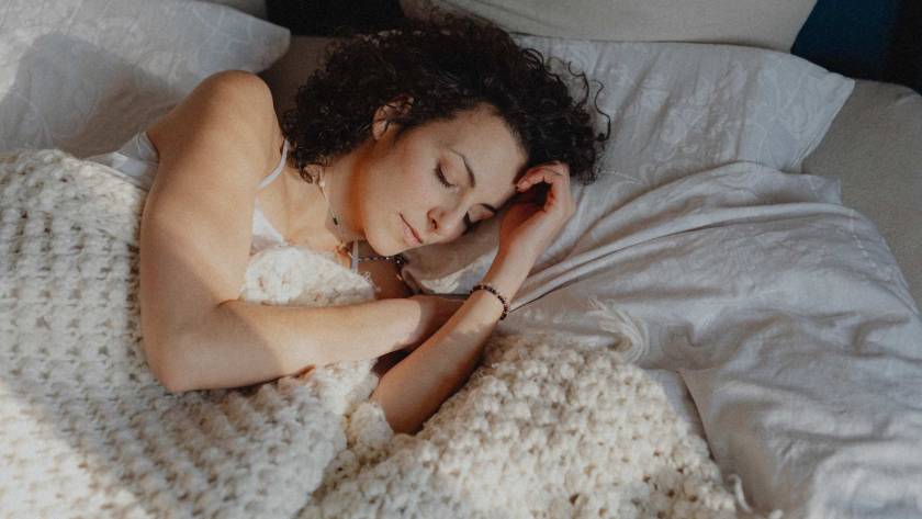A woman resting in warm light, head bowed, illustrating a post about burnout and perfectionism
