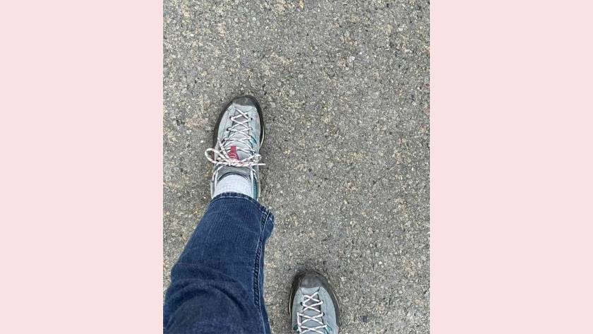 Looking down at feet mid-stride on a tarmac path, an ordinary everyday walk